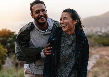 couple in jackets walking on path.